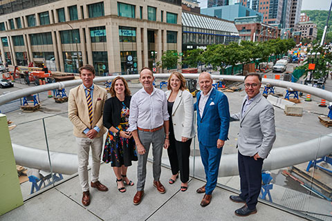 Members of the Ivanhoe Cambridge team, clients of the Exponentiel communications agency, in front of the Place Ville-Marie ring